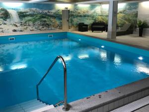 a large pool with blue water in a hotel lobby at Alpenstubn - Chiemgau Karte in Inzell