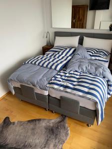 a bed with blue and white striped sheets on it at Inspiration Maisonette in Scharbeutz