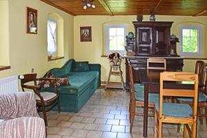 a living room with a green couch and a table at Chalupa Mája in Hřensko
