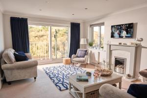 sala de estar con chimenea y TV en Port Side - Boutique Home with Outstanding River Views en Kingswear