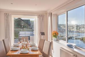 a dining room with a table and a large window at Port Side - Boutique Home with Outstanding River Views in Kingswear