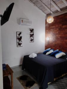 a bedroom with a bed with blue pillows at Pousada Santa Vila in Serra do Cipo