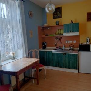 a kitchen with a wooden table and a sink at Villa Rosenberg in Mariánské Lázně