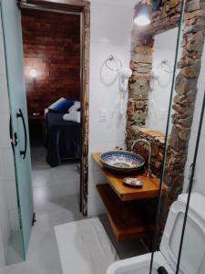 a bathroom with a sink and a bedroom with a bed at Pousada Santa Vila in Serra do Cipo