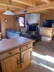 a kitchen and living room with a couch and a table at Chalet à la montagne in Champoussin