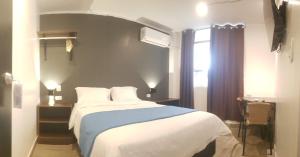 um quarto com uma cama grande e uma janela em Hospedaje Diamantes em Huacho