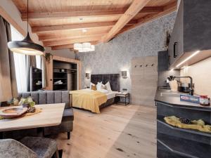 Habitación de hotel con cama, cocina y sala de estar. en MYALPS Ötztal, en Umhausen