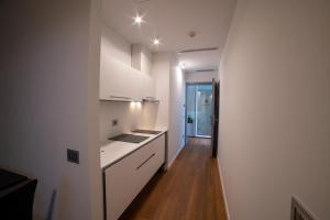 a kitchen with white cabinets and a wooden floor at GRANDI 32 Boutique Residence in Segrate