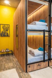 a room with bunk beds with yellow walls at HiLoft Hostel in Sochi