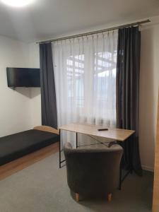 a room with a desk and a chair and a bed at Sveciu Namai Giles in Alytus