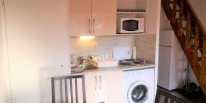 a kitchen with a washing machine and a microwave at Résidence Cap Azur Appartement 237 in Villeneuve-Loubet