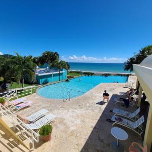 a pool with chairs and the ocean in the background at Parador Maunacaribe - Maunabo in Maunabo