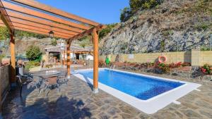a swimming pool with a pergola next to a house at Villa La Cola Nerja by Ruralidays in Nerja