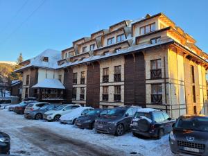 a large building with cars parked in front of it at Apart1305zoned2 in Kopaonik