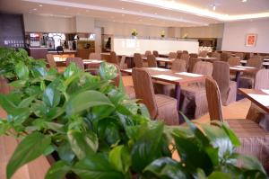 a restaurant with tables and chairs and potted plants at Fushin Hotel Taichung in Taichung