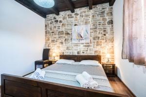 a bed in a room with a stone wall at Holiday Home Sandra in Sukošan +33 photos