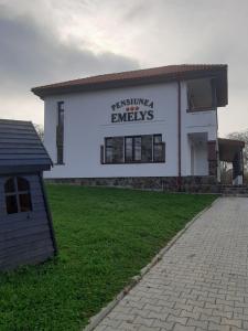 a white building with a sign on the side of it at Pensiunea Emelys in Iaşi