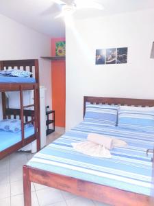 a bedroom with two beds and a bunk bed at SUITES COR DO SOL TRINDADE in Trindade