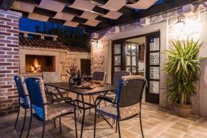 a patio with a table and chairs and a fireplace at Holiday Home Sandra in Sukošan