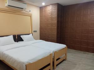 a bedroom with a bed and a wall with a projector at Soukyam Hotel in Kolkata