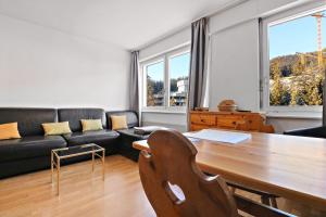a living room with a table and a couch at Studio cosy au centre de Crans-Montana (1-4 personnes) in Crans-Montana