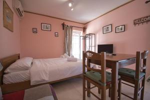 1 dormitorio con 1 cama y escritorio con ordenador en Tiny Studio Marousi area, en Atenas