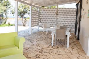 - un patio avec une table et des chaises sur un sol en pierre dans l'établissement Villa Playa dell est, à Torre Santa Sabina