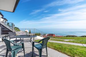 a patio with a table and chairs and the ocean at Sunset Surf - Mount Brioni in Downderry