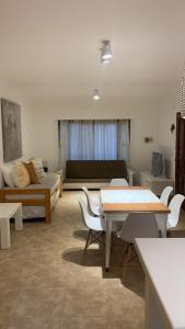 sala de estar con mesa, sillas y sofá en La Casita del Mar en Ostende