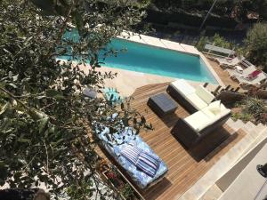 una piscina con terrazza e sedie e una piscina di Villa Marcelline Belle vue mer Golfe de Saint Tropez a Saint-Peïre-sur-Mer