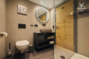 un baño con inodoro y espejo en Chalet Goldstück, en Oberstaufen 19 fotos más