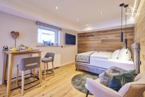 a bedroom with a bed and a desk and chairs at Chalet Goldstück in Oberstaufen