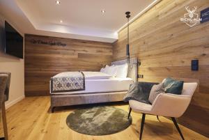 Un dormitorio con una cama, un sofá y una silla. en Chalet Goldstück, en Oberstaufen