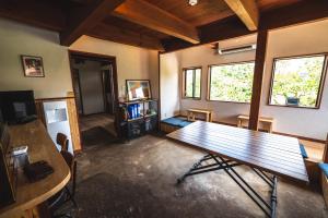 Habitación con mesa de madera en una habitación en 古民家ゲストハウスひまわり, en Isa