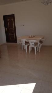 a table and two white chairs in a room with a door at شاليه الفاخريه in Madain Saleh