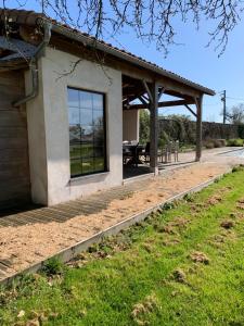 uma casa com um alpendre e um pátio em Au p’tit bonheur d’Augé em Augé