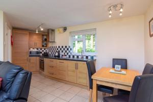 a kitchen with a table and a dining room at Cornish Riviera - Mount Brioni in Downderry