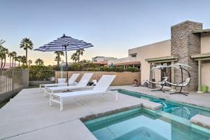 a pool with two lounge chairs and an umbrella at Mid-Century Resort Home with Mtn and Golf Views! in Palm Springs