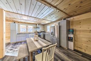 cocina con techo de madera y mesa de madera en Rangeley Retreat Cabin-Style Home Lake Access, en Rangeley