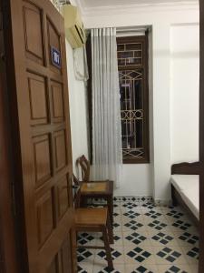 Habitación con puerta, silla y ventana en NHÀ NGHỈ THÀNH THU en Hanói