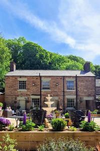 a large brick building with a fountain in front of it at The Family Tree in Whatstandwell