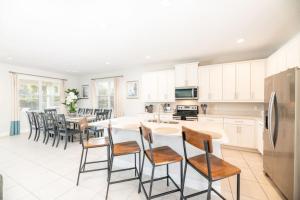 a kitchen with white cabinets and a table and chairs at Spacious 8 BDR Family Home with Arcades and Free Pool Heat in Orlando