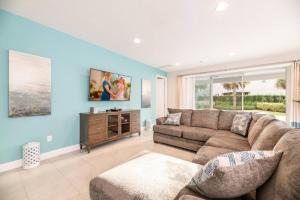 uma sala de estar com paredes azuis e um sofá em Spacious 8 BDR Family Home with Arcades and Free Pool Heat em Orlando