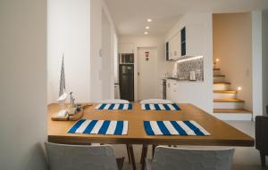 uma cozinha e sala de jantar com uma mesa de madeira e cadeiras em Villa Mar - Maia em Maia