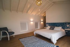 een slaapkamer met een bed en een stoel bij Villa Mar - Maia in Maia