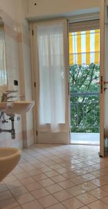 un bagno con due lavandini e una porta scorrevole in vetro di Hotel Villa Platani a Riccione