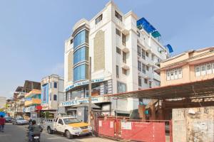una concurrida calle de la ciudad con edificios y un camión en Hotel Mart View en Kochi