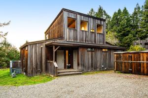 une grange en bois avec une porte et une clôture dans l'établissement The Bobcat House, à Sea Ranch