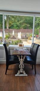 a dining room table with two chairs and a window at The Family Tree in Whatstandwell
