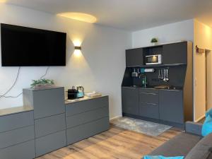 a living room with a kitchen with a tv on the wall at Ferienwohnung Jagdhof Spitzingsee in Schliersee